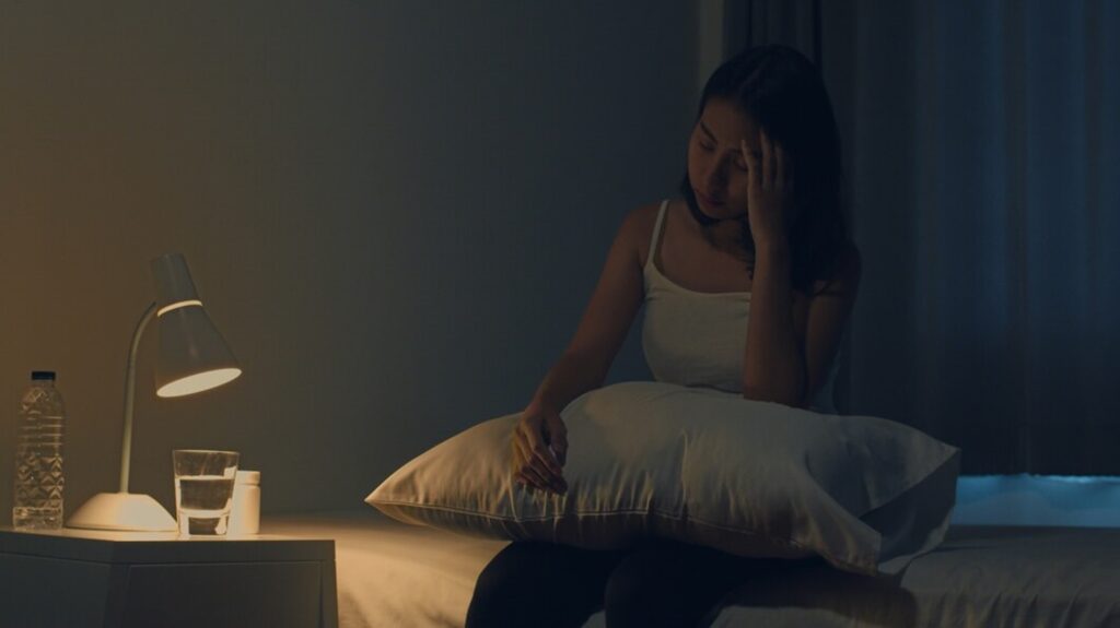 causas del insomnio: chica sin poder dormir en la cama