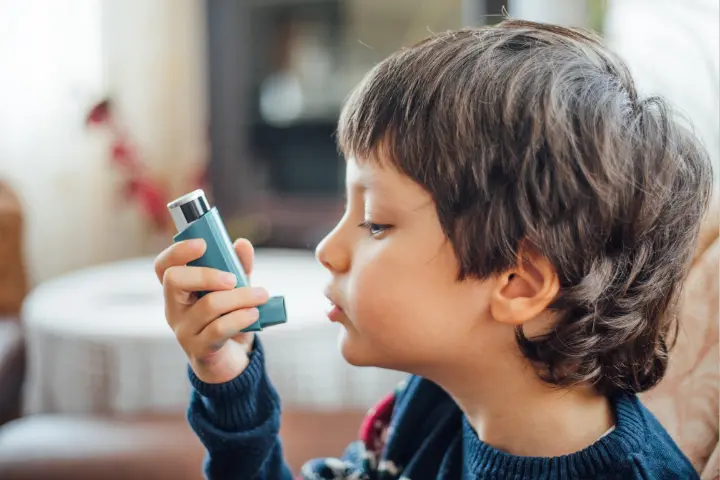 Bronquitis y asma: niño mirando un inhalador 