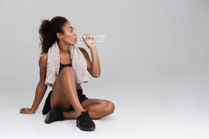 metabolismo basal ideal: chica bebiendo de una botella de agua