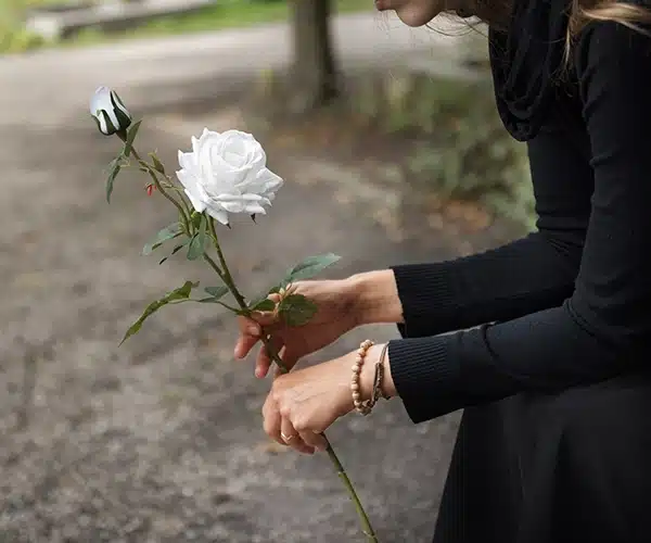 mujer dejando flores tras el fallecimiento de un familiar